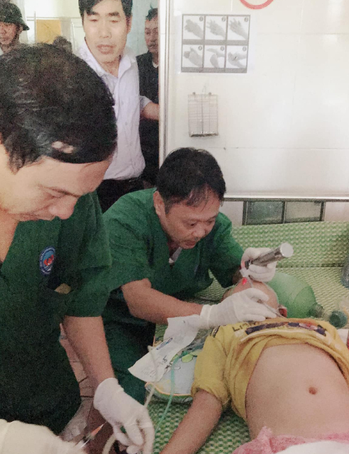 Các bác sĩ Bệnh viện Đa khoa huyện Cẩm Xuyên đặt nội khí quản cho bệnh nhi trưa 20/10. Ảnh: Hoàng Thúy Anh.