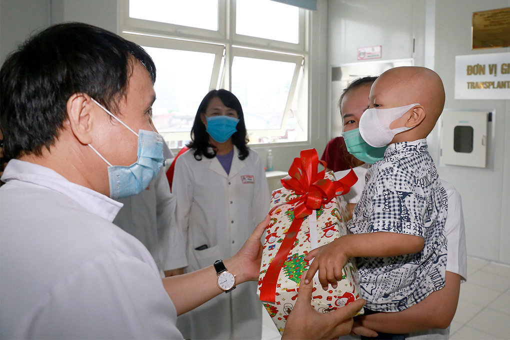 Giáo sư, tiến sĩ Phạm Như Hiệp tặng quà cho bé trai 2,5 tuổi trước lúc xuất viện. Ảnh: VnExpress