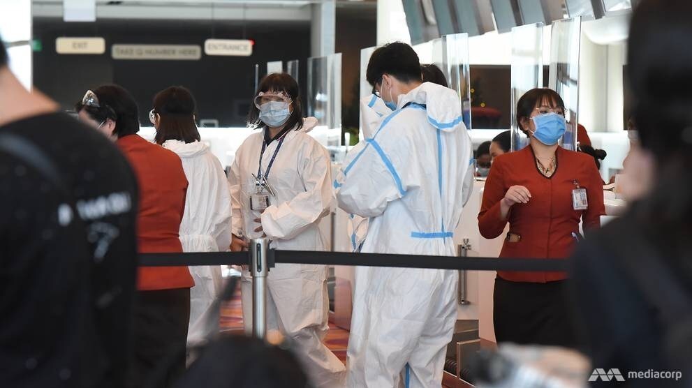 Nhân viên sân bay mặc đồ bảo hộ và đeo khẩu trang phòng dịch tại sân bay Changi, Singapore trong tháng này. Ảnh: CNA.
