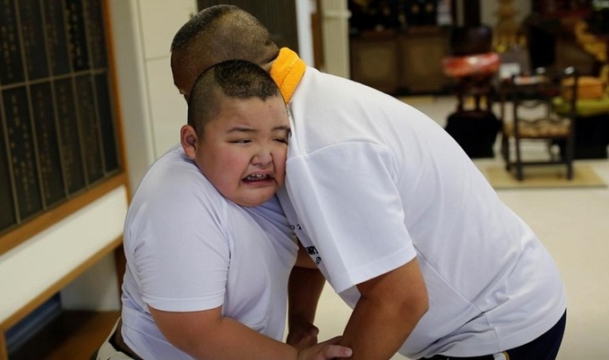 Kyuta Kumagai, 10 tuổi, luyện tập sumo với cha mình là Taisuke, 50 tuổi, trong một buổi huấn luyện riêng mà cha cậu tổ chức tại chùa Phật giáo Joshin-ji ở Tokyo, Nhật Bản, ngày 2 tháng 9 năm 2020. Ảnh: Reuters.