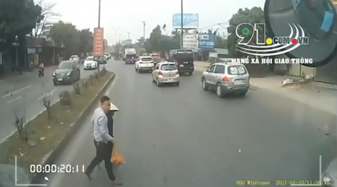 Hình ảnh nam tài xế ô tô chủ động dừng xe, đưa cụ bà sang đường