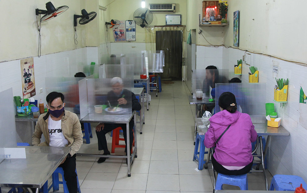 Một quán ăn tại Hà Nội thực hiện biện pháp chống dịch. (Ảnh: Hà Nội Mới)