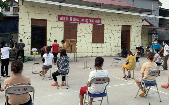 Công nhân trọ tại thôn Giá, xã Nội Hoàng (Yên Dũng) thực hiện giãn cách trước khi vào 'siêu thị 0 đồng'. Ảnh: Báo Bắc Giang.