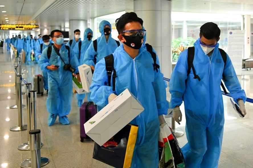 Trên chuyến bay từ UAE các thành viên của tuyển Việt Nam đều mặc đồ bảo hộ theo đúng quy định - Ảnh: TTXVN