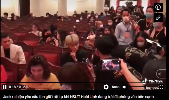 Jack ra hiệu yêu cầu fan giữ trật tự khi NSƯT Hoài Linh đang trả lời phỏng vấn bên cạnh - Ảnh chụp màn hình