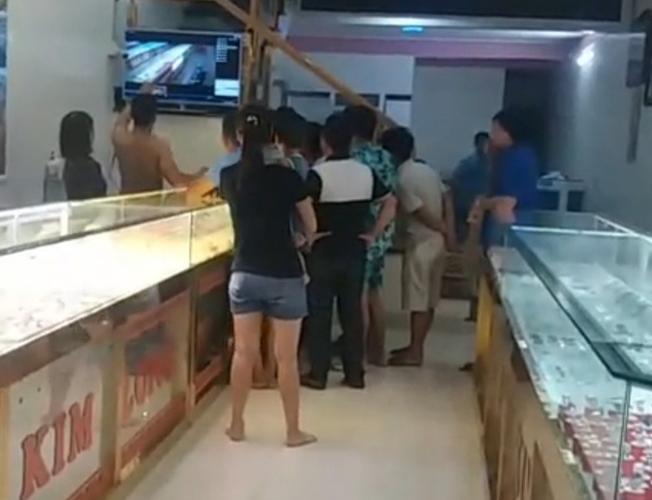 Chủ tiệm và người dân xem lại camera ghi hình vụ cướp