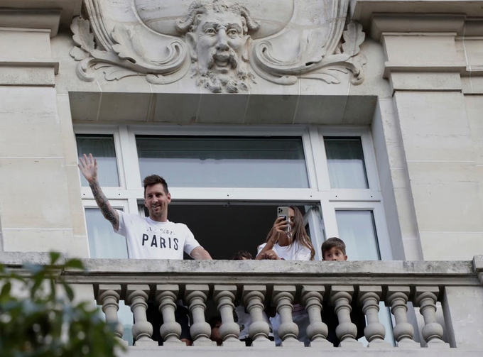 Messi và vợ con vẫy tay chào người hâm mộ từ ban công khách sạn Le Royal Monceau.
