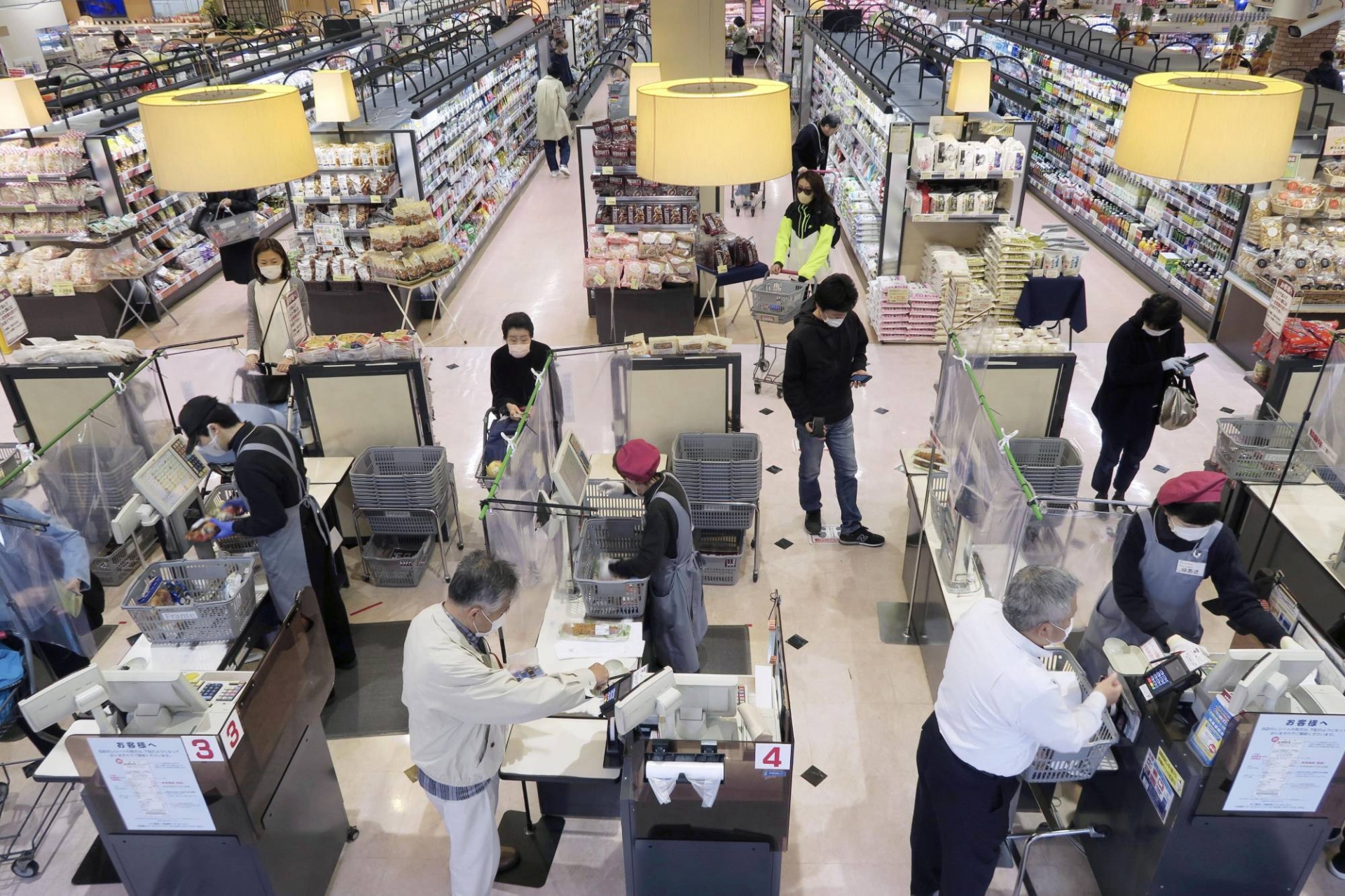 Một tấm rèm bằng tấm nhựa được đặt giữa nhân viên thu ngân và người mua hàng tại một siêu thị Nhật Bản.