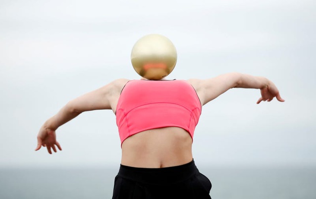 Đầu của vận động viên thể dục nhịp điệu Lynne Karina Hutchison của đội tuyển Vương quốc Anh đang ẩn sau quả bóng.