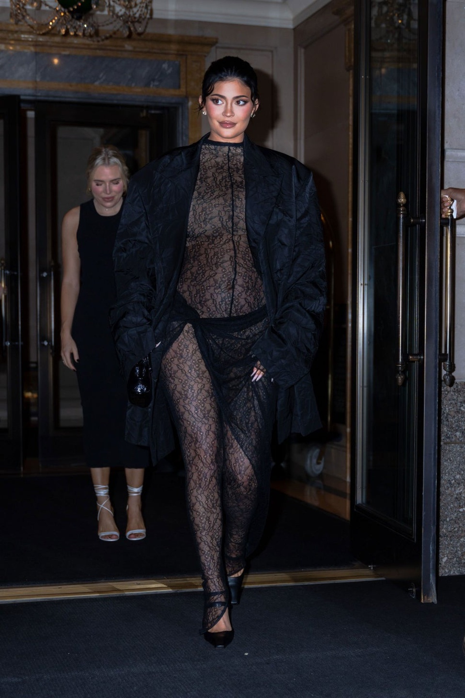 Kylie Jenner diện bộ jumpsuit ren xuyên thấu bó sát cơ thể, lộ rõ bụng bầu qua lớp vải mỏng. Người đẹp cũng mặc kèm áo blazer oversize