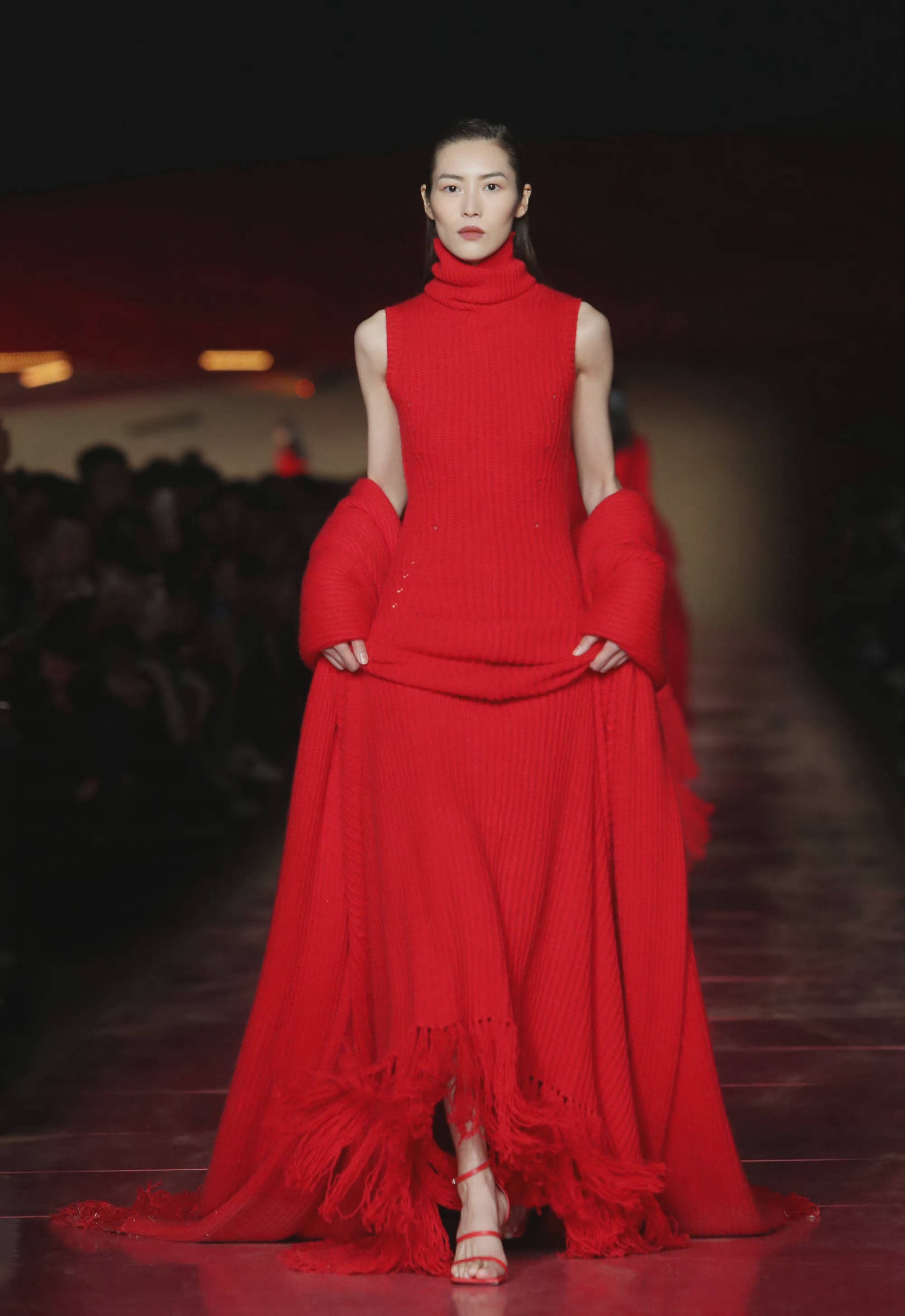 Liu Wen toát lên khí chất sang chảnh khi sải bước trên sàn catwalk. Cô nàng tạo điểm nhấn bằng bộ trang phục len cổ lọ dáng dài màu đỏ rực rỡ, mái tóc của nữ người mẫu được chải ngược ra sau càng giúp cô thêm phần 'high fashion'.