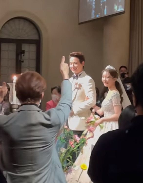 Lee Ji Hoon trong bộ vest màu trắng lịch lãm sánh đôi cùng cô dâu Ayane trong bộ váy trắng tinh khôi tiến vào buổi tiệc