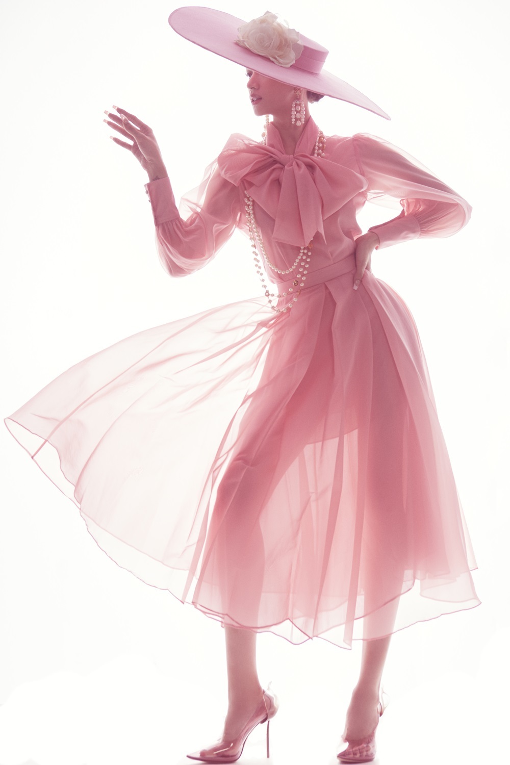 Chiếc đầm hồng với chất liệu voan xuyên thấu quyến rũ khoe triệt để vóc dáng thanh mảnh, cuốn hút của hoa hậu sinh năm 1991. Dù trang phục có nhiều layer, điển hình chiếc nơ voan trước cổ, nhưng vẫn tạo cảm giác duyên dáng, thanh lịch
