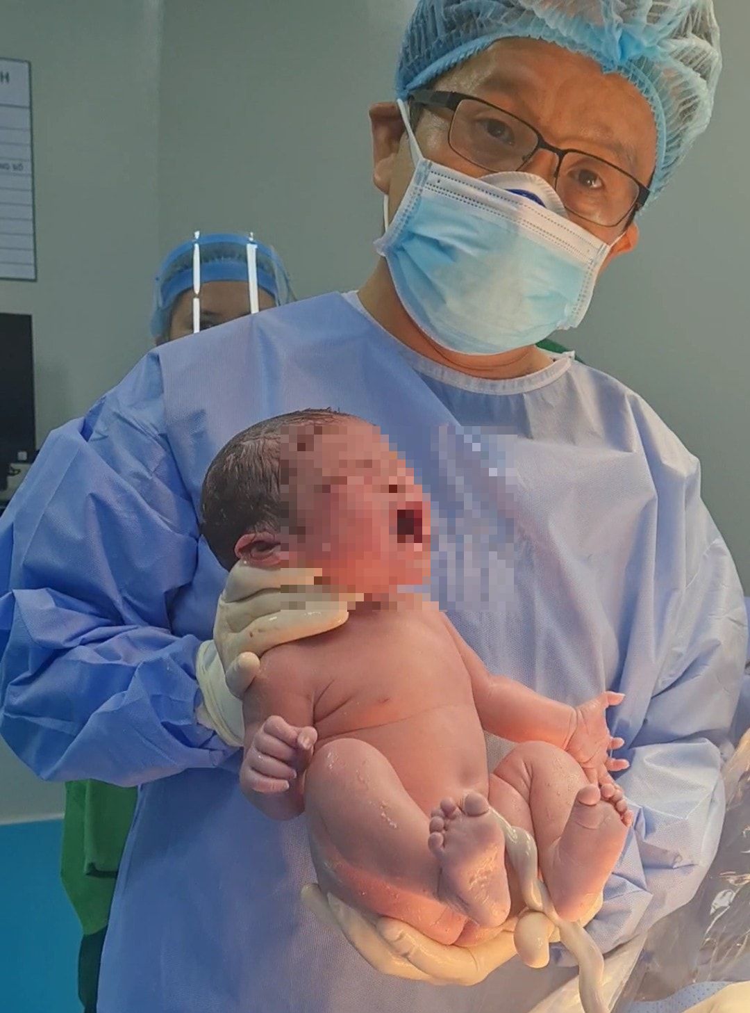 Bác sĩ Nguyễn Hữu Trung bên cạnh em bé vừa chào đời