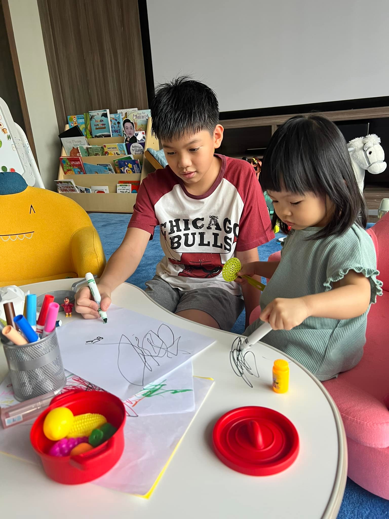Khi anh cả đang nhiệt tình dạy em gái vẽ trên giấy thì Suchin chỉ thích 'sáng tác hội họa' trên mặt bàn.