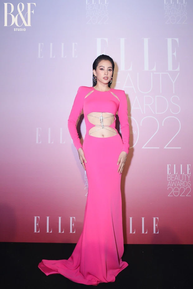 Trái với Lương Thùy Linh, Hoa hậu Tiểu Vy diện mẫu đầm hồng cánh sen rực rỡ với chi tiết cắt xẻ độc đáo, làm tôn lên vòng eo không mỡ thừa, cùng đường cong cuốn hút