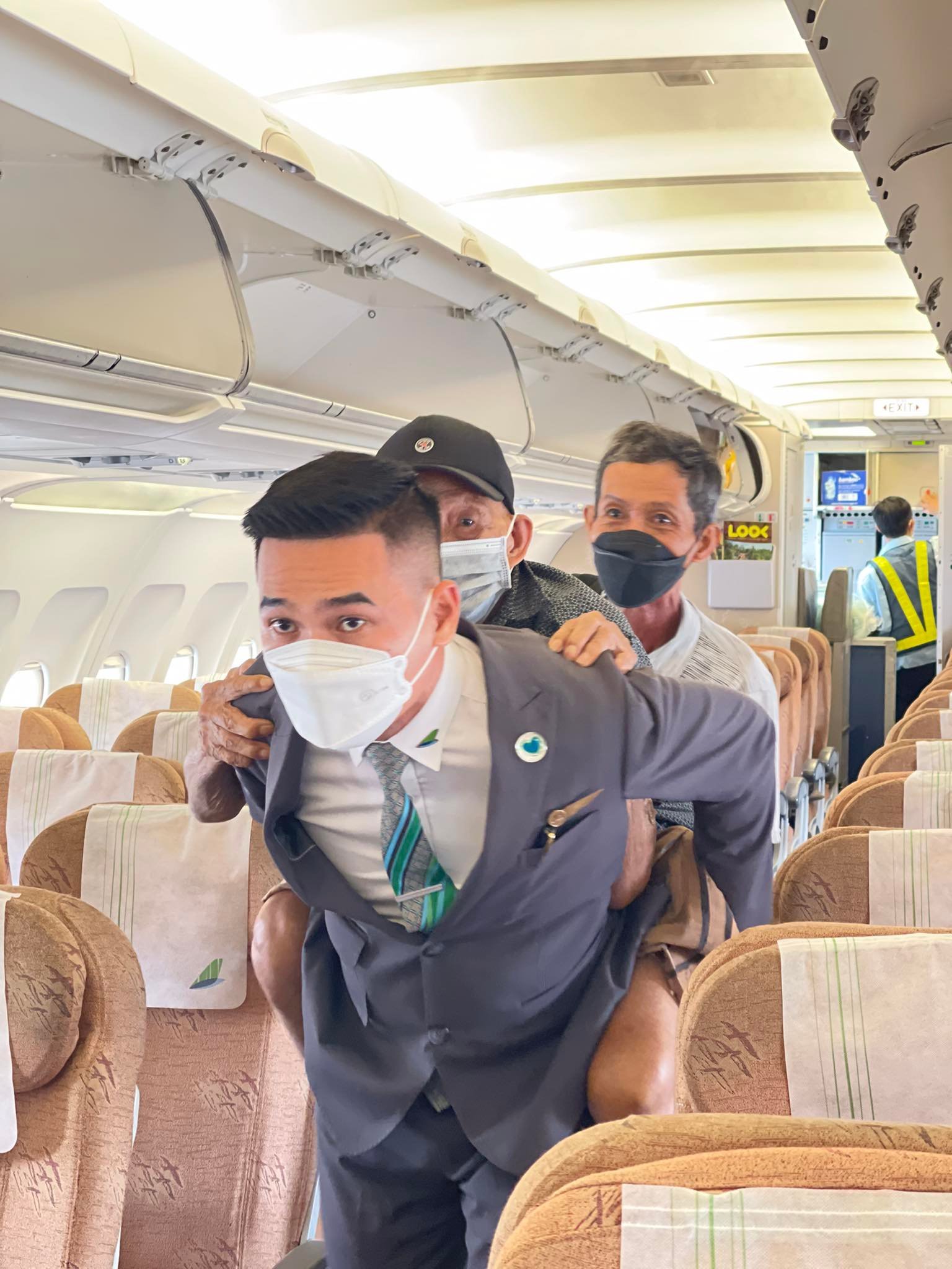 Cảm động hình ảnh cụ ông 70 tuổi cõng người cha 90 tuổi trên máy bay - Ảnh 1