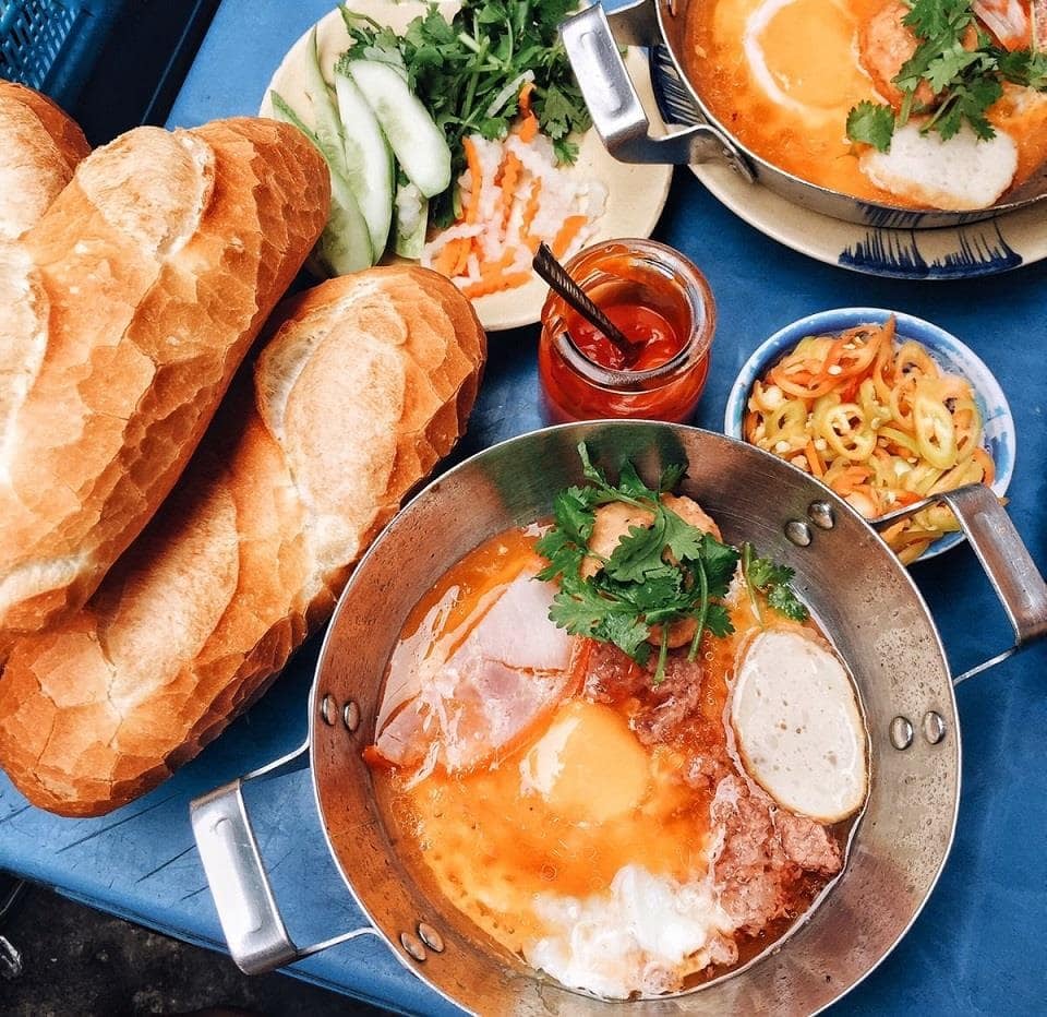 Một trong những món ăn sáng đặc trưng của Sài Gòn là bánh mì chảo, gồm đầy đủ các topping như: trứng, thịt nguội, chải lụa, pate... kèm dưa chua và bánh mì. Tuy đơn giản nhưng đây lại là bữa sáng đầy dinh dưỡng, thích hợp để 'ăn mừng' nhân ngày Sài Gòn 'mở cửa' đấy nhé.