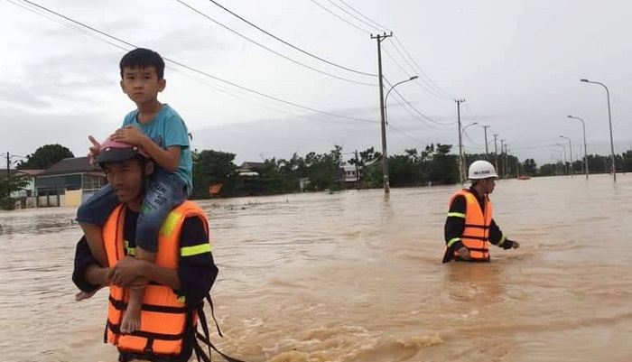 Công an tỉnh Quảng Trị lội nước lũ chảy siết đưa người dân đến nơi an toàn. Ảnh: Vietnamnet.