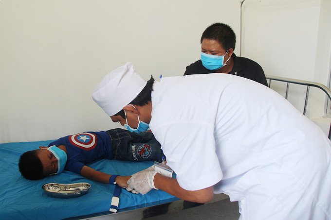 Bác sĩ lấy mẫu xét nghiệm bạch hầu tại Trung tâm Y tế huyện Krông Nô, Đắk Nông hồi tháng 6. Ảnh: VNEpress