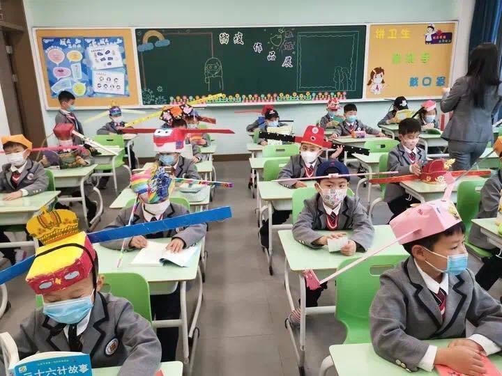 Các học sinh Trung Quốc và chiếc mũ giữ khoảng cách. Ảnh: Da Rui