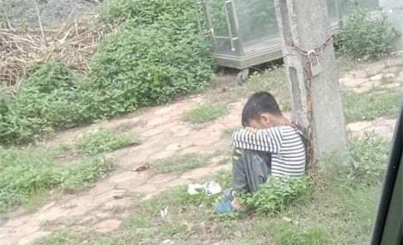 Lạng Sơn: Lười học, bé trai 10 tuổi bị cha ruột xích cổ khóa ở cột điện ven đường - Ảnh 1