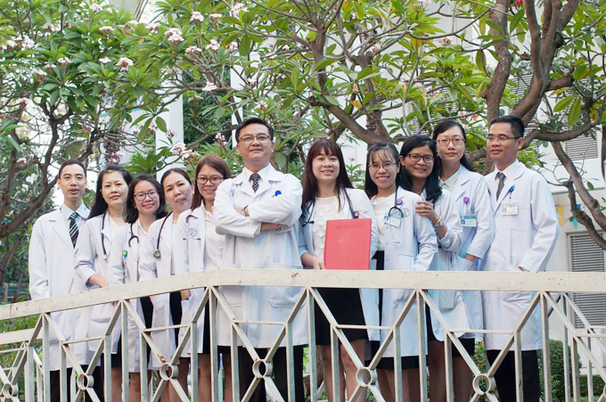 Bác sĩ Võ Ngọc Anh Thơ (tóc dài, đứng giữa) cùng TS.BS Lê Quốc Hùng và ekip Khoa Bệnh nhiệt đới Bệnh viện Chợ Rẫy.
