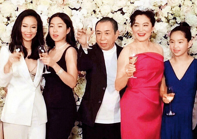 Vợ chồng ông Hình Lý Nguyên - Lâm Thanh Hà (váy đỏ) và ba con gái tại một sự kiện năm 2016.