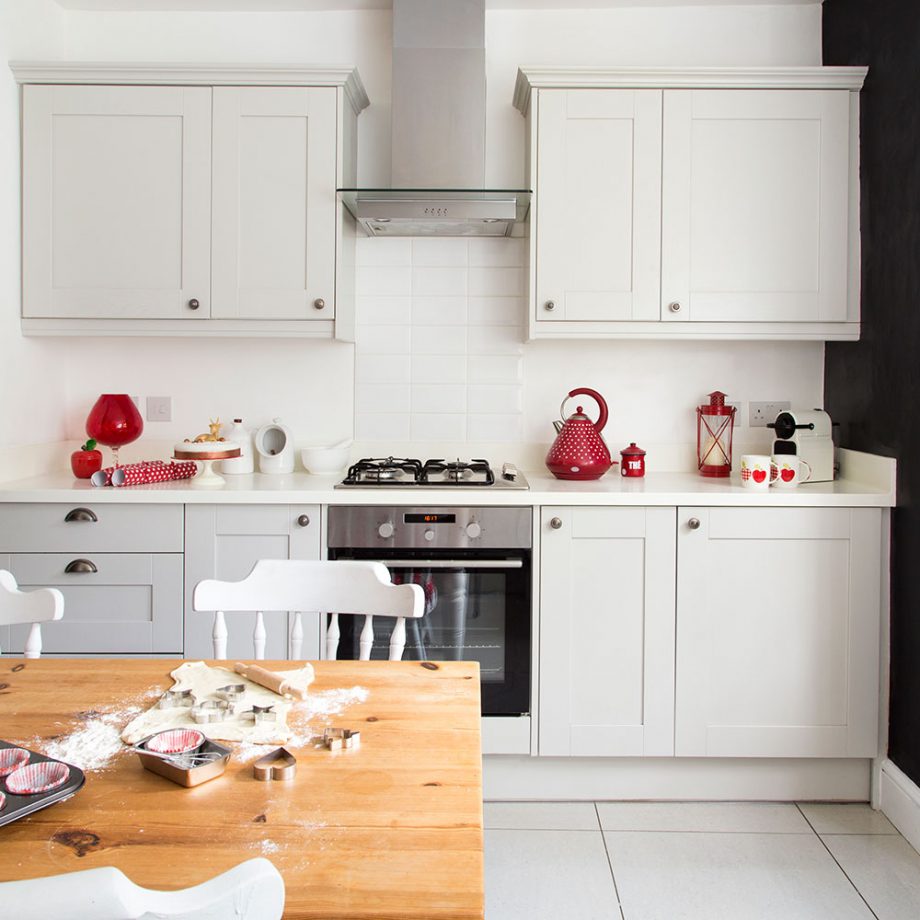 Vài món nội thất màu đỏ chính là điểm nhấn nổi bật cho căn bếp trắng.