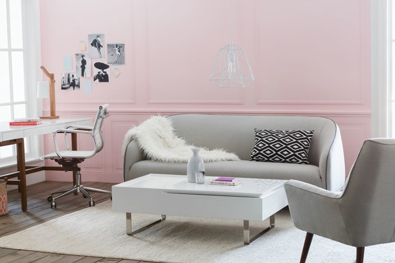 Một phòng khách khá nhỏ khi phải chia đôi chức năng cho một góc làm việc tại gia, tuy nhiên vẫn tạo được dấu ấn nhờ bức tường sơn màu hồng pastel, kết hợp với gam màu xám trung tính của đồ nội thất nên không quá điệu đà.