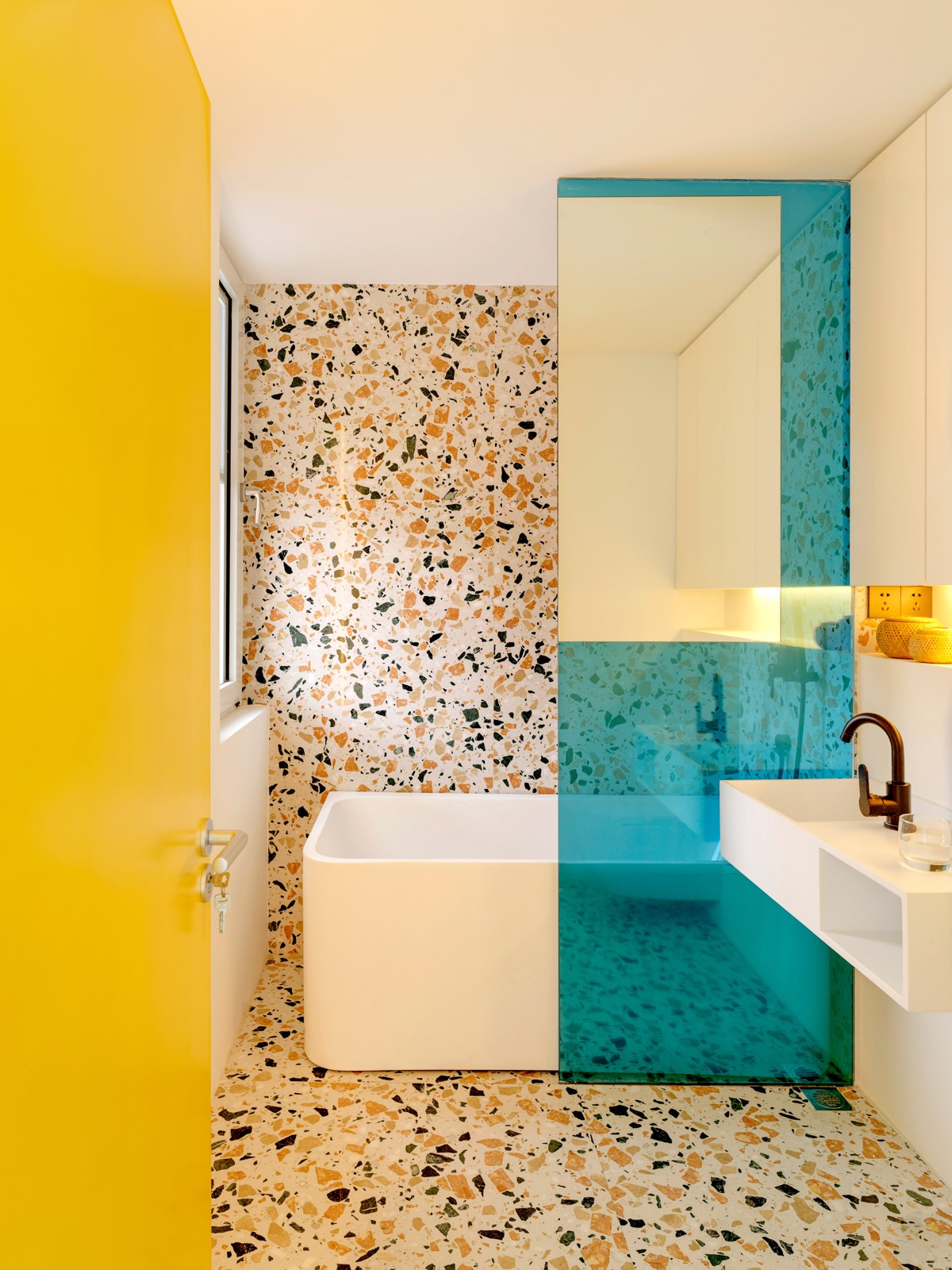 Phòng tắm có sự kết nối về tổng thể với bếp nhờ màu xanh ngọc và hoa văn terrazzo.