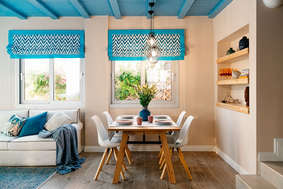 Trần nhà màu xanh bắt mắt với rèm cửa sổ, gối tựa sofa và lọ hoa cùng tone sur tone mang lại cho phòng ăn không gian mùa thu đặc trưng phong cách Địa Trung Hải tươi mới.