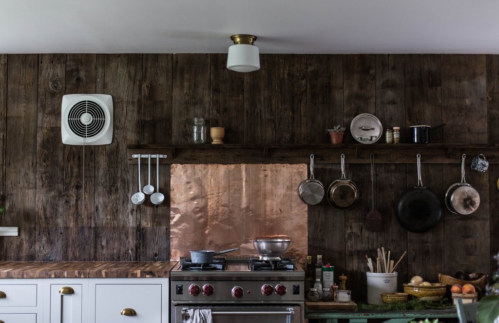 Trong căn bếp thô sơ này, bạn sẽ nhìn thấy bức tường gỗ tối màu tương phản với tấm vàng đồng sáng ấm áp ngay phía sau bếp nấu. Đó chính là sự thông minh khi kết hợp giữa chủ đề mộc mạc nhưng thêm điểm nhấn sang trọng nhỏ cho hiệu quả tối đa.