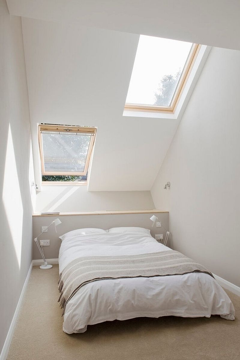 Phòng ngủ nhỏ nhưng cực kỳ xinh xắn với trần nghiêng đón nắng. Từ bức tường cho đến bộ chăn ga gối cũng đều tuân thủ tông màu trắng chủ đạo, thêm chút sắc xám nhẹ nhàng cho chiếc giường thêm duyên dáng.