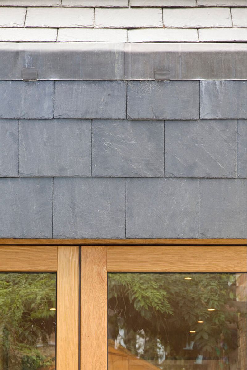 Phần gạch ốp tường màu xám sang trọng kết hợp với vật liệu gỗ và kính cho ngôi nhà một vẻ đẹp hoàn hảo.
