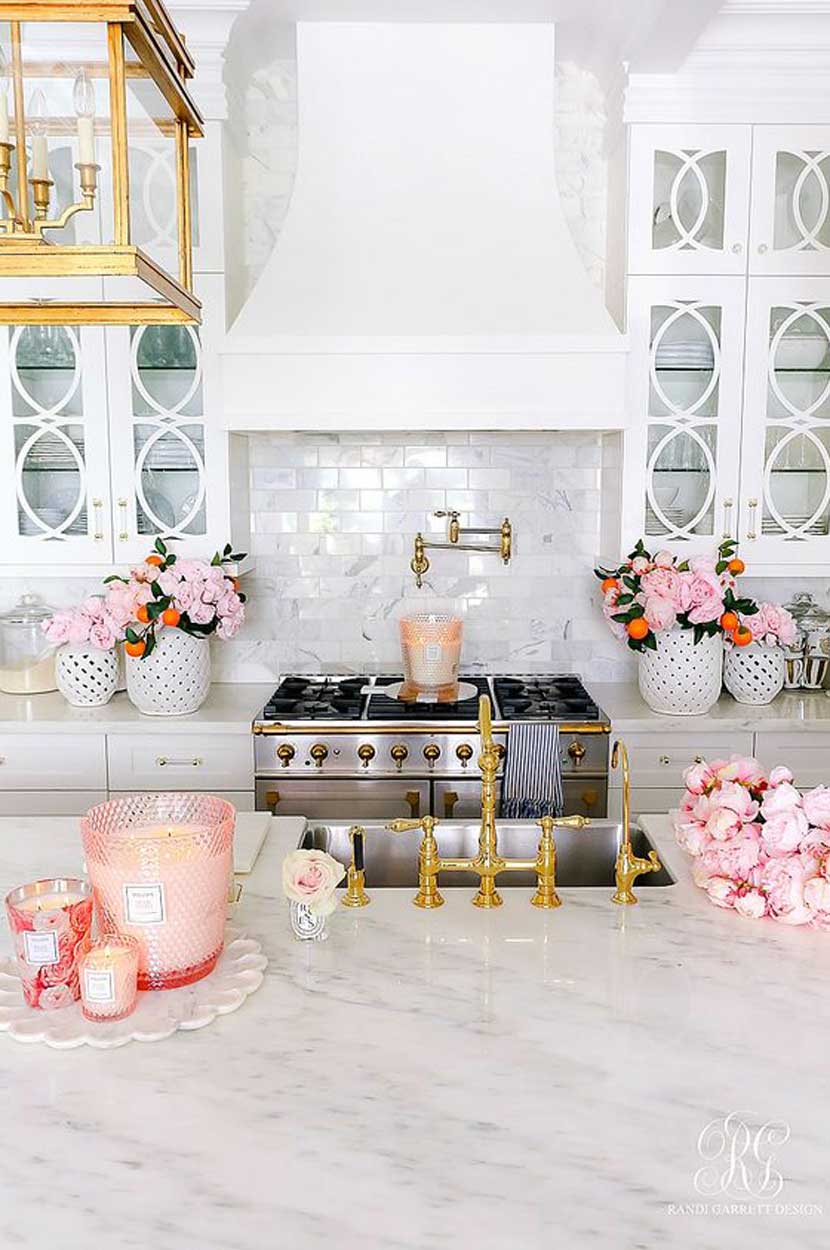 Góc bếp nhỏ xinh không sử dụng nội thất màu hồng mà thay vào đó là tạo nét thu hút bằng phụ kiện trang trí, cụ thể là nến và hoa. Những lọ nến hồng phấn, kết hợp với rất nhiều bó hoa tươi khiến không gian tươi tắn và sinh động.