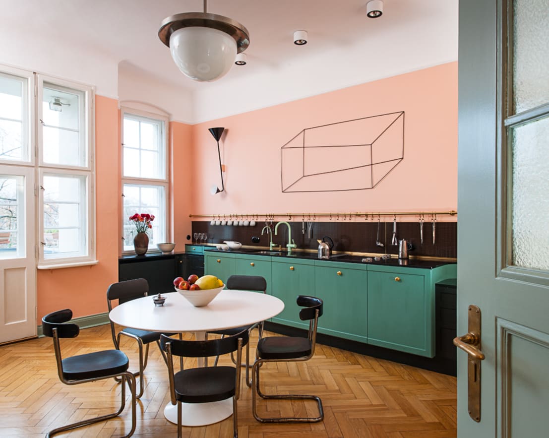 Thay vì sử dụng màu hồng làm điểm nhấn cho các phòng bếp tông màu trắng chủ đạo như vài ví dụ trên, hãy để sơn tường màu hồng trở thành trung tâm và chiếc tủ bếp màu xanh ngọc cá tính điểm tô cho nó!
