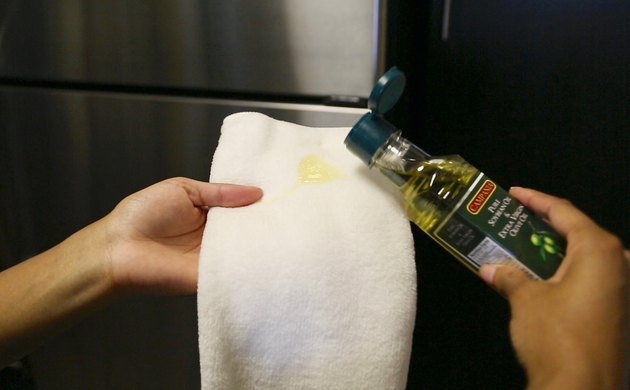 Cho một vài giọt dầu ô liu vào miếng vải hoặc khăn mỏng.