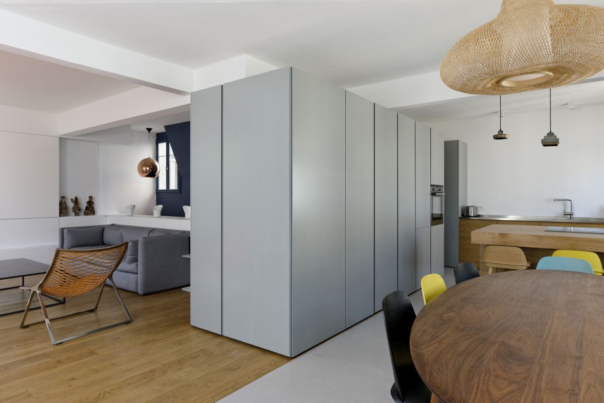 Phân tách phòng khách với bếp và khu vực ăn uống là chiếc tủ lưu trữ thay thế cho bức tường thô cứng.