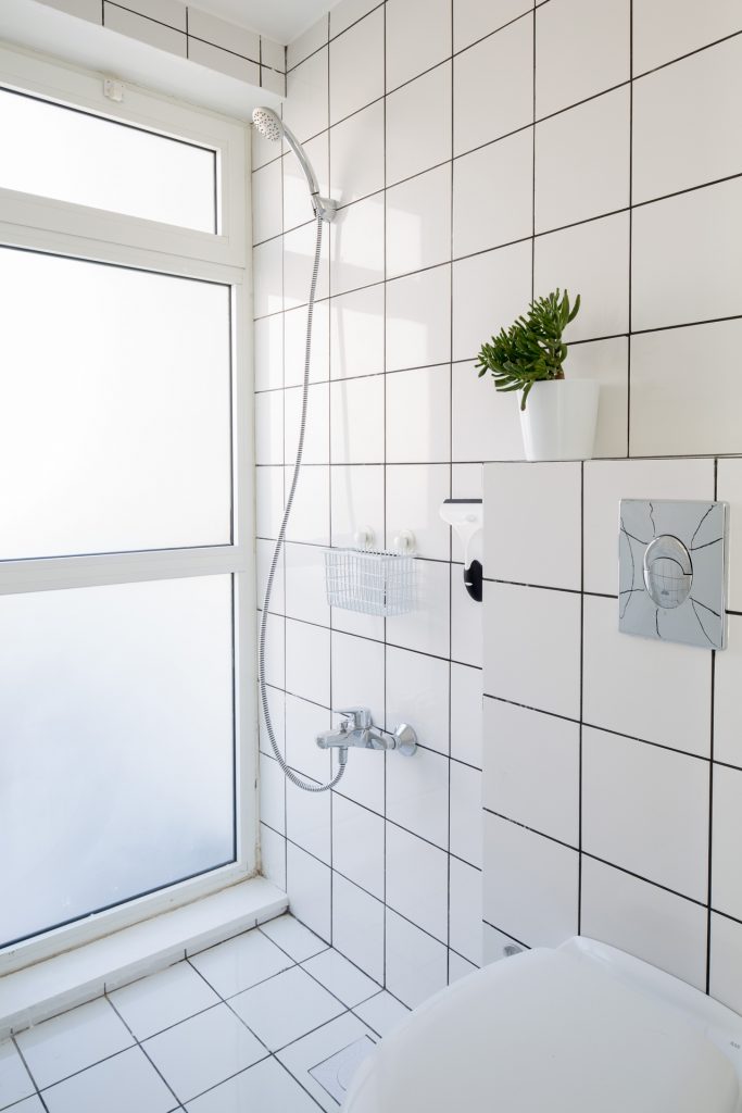 Những viên gạch ô vuông trên bức tường phòng tắm và nhà bếp giúp phân vùng chức năng với phòng khách và phòng ngủ một cách nhẹ nhàng.