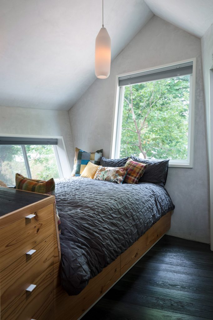 Phòng ngủ nhỏ thi vị với những ô cửa nghiêng nghiêng theo theo kiến trúc ngôi nhà.