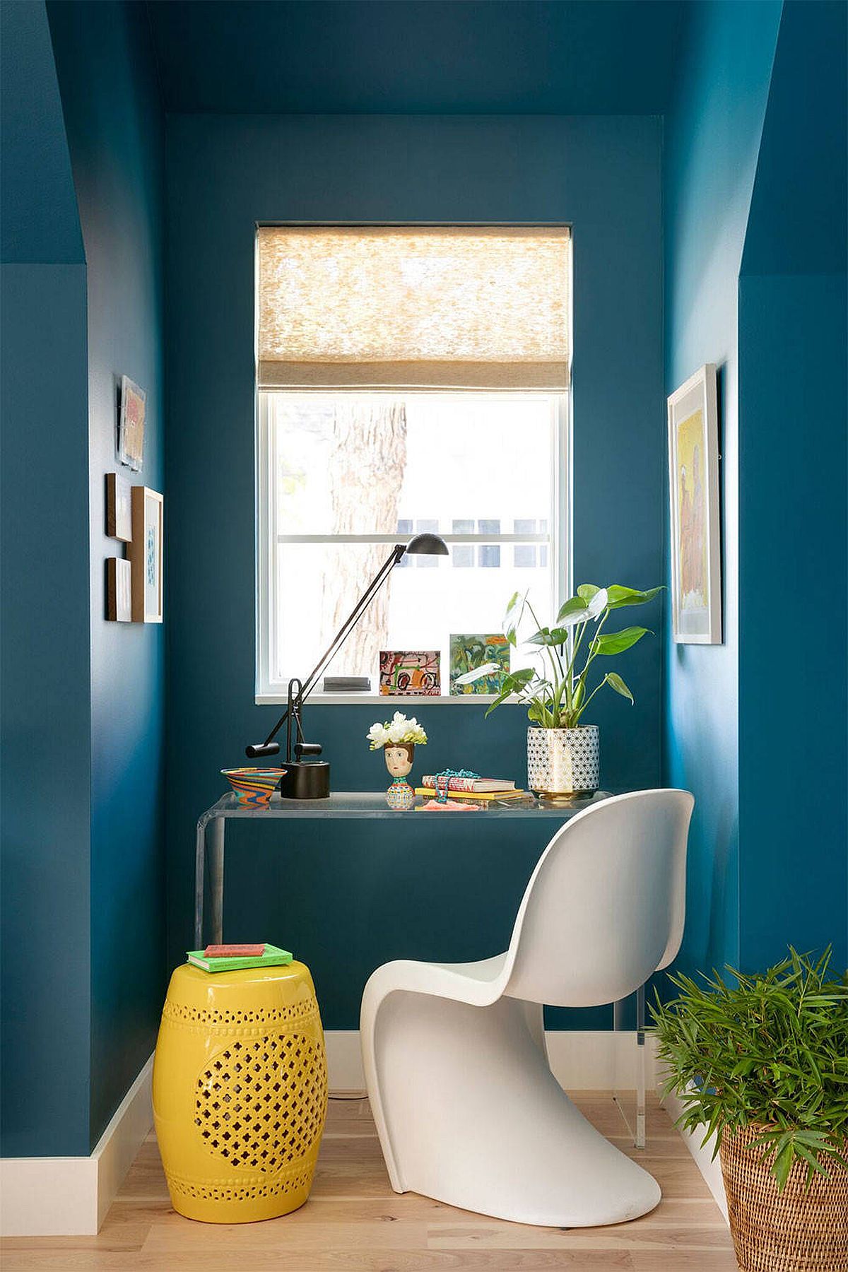 Tận dụng tối đa nguồn sáng tự nhiên qua ô cửa nhỏ khiến góc làm việc màu xanh lam bừng sáng đầy cảm hứng, thêm vào chiếc ghế đôn màu vàng khiến không gian trở nên ấm áp hơn.