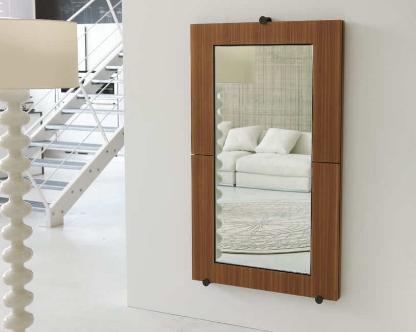 Chiếc gương soi hình chữ nhật khung gỗ giản dị trên bức tường phòng khách.