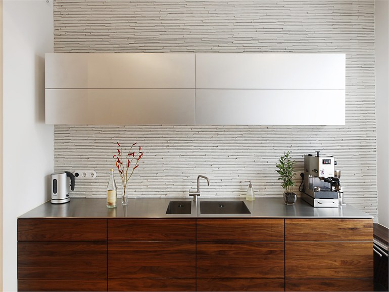 Lựa chọn vật liệu gỗ tối màu cho tủ bếp dưới và thép không gỉ cho tủ bếp trên tạo nên cái nhìn vừa mộc mạc vừa hiện đại, kết hợp ánh sáng từ cửa sổ cho hiệu ứng sáng bóng hơn hẳn.