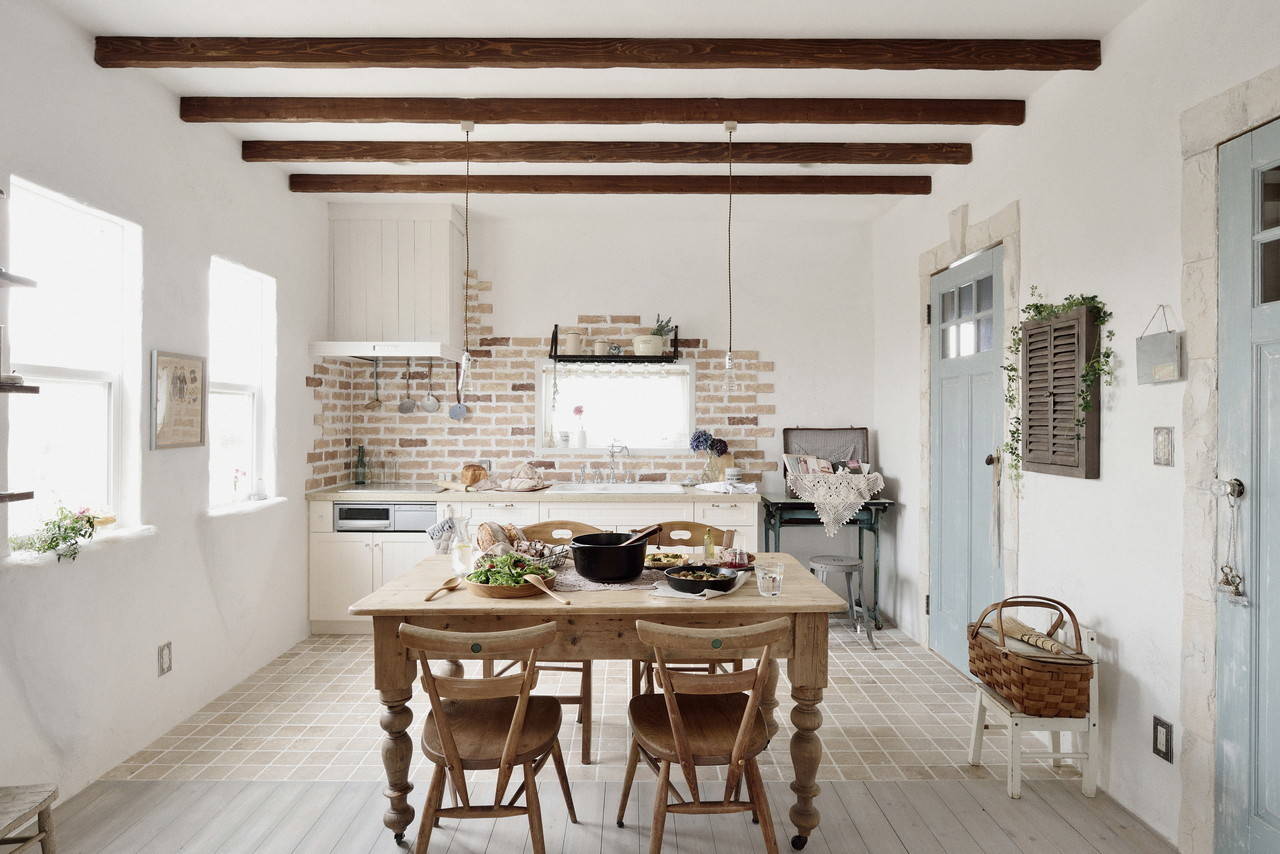 Phòng bếp với phong cách rustic mộc mạc, từ phần dầm trên trần nhà, bộ bàn ghế ăn cho đến khu vực backsplash được lát gạch cho cảm giác thô sơ gần gũi đến lạ.