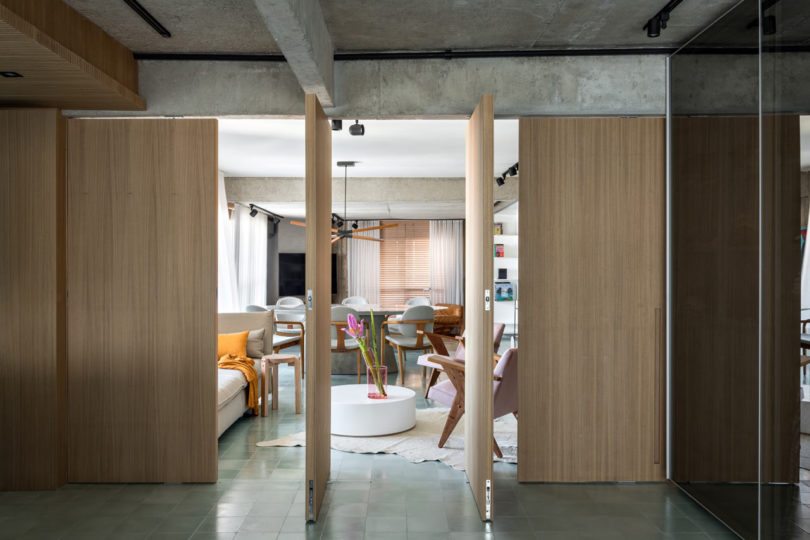 Điểm ấn tượng nhất và cũng là sự thông minh trong thiết kế của căn hộ chính là hệ cửa gỗ xoay cho phép phân tách không gian phòng khách và phòng ngủ.