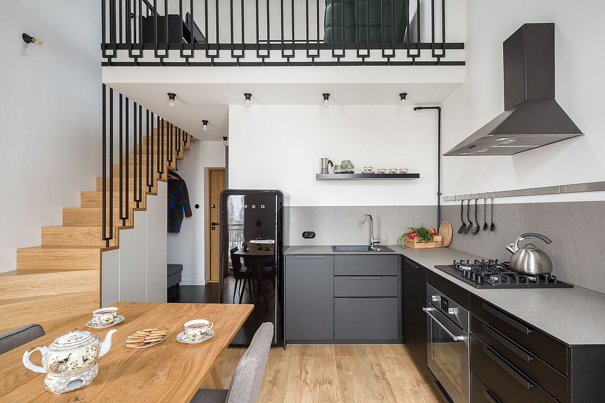 Tầng dưới là phòng bếp, khu vực ăn uống thiết kế mở với gam màu trắng chủ đạo, kết hợp nội thất màu đen và xám cho cái nhìn lịch lãm, sang trọng. 