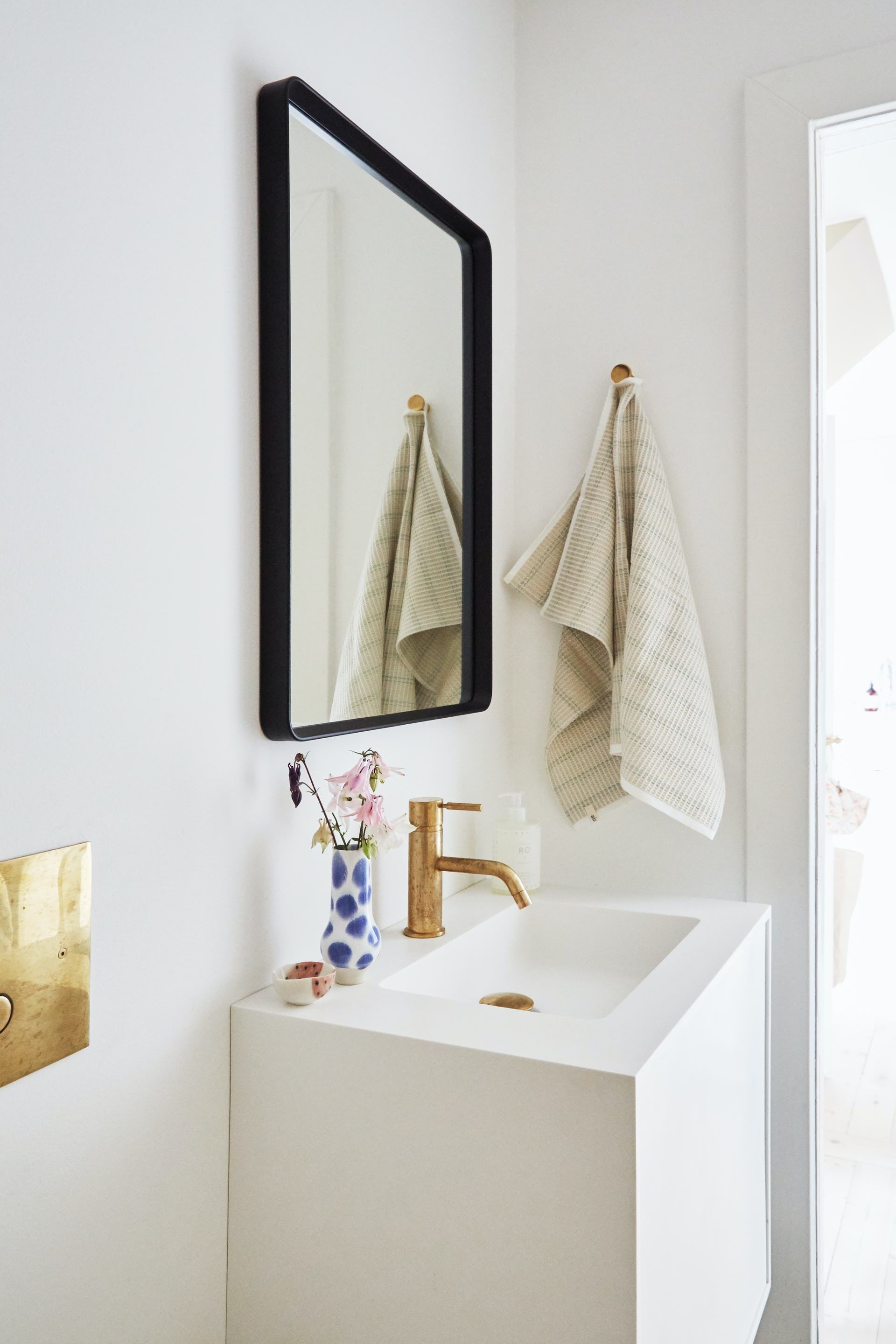 Lọ hoa sứ duyên dáng trên bồn rửa, tấm gương soi đơn giản nhưng mang lại hiệu quả “cơi nới” không gian.