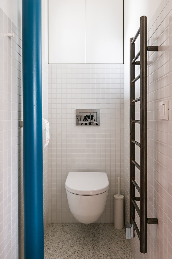 Phòng tắm có diện tích nhỏ, dài và hẹp nên được bố trí toilet gắn tường để giải phóng diện tích mặt sàn. Kệ lưu trữ hình chiếc thang dùng để treo quần áo và khăn tắm tiện lợi.