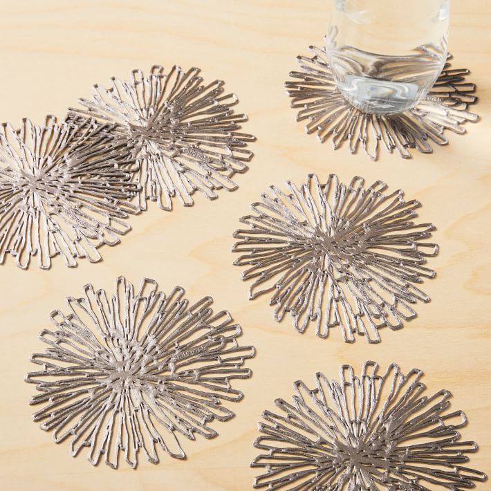 Bộ lót cốc bằng kim loại với hình ảnh những bông hoa cúc bằng bạc nở rộ cho bàn nước phòng khách thêm lấp lánh ánh nhìn.